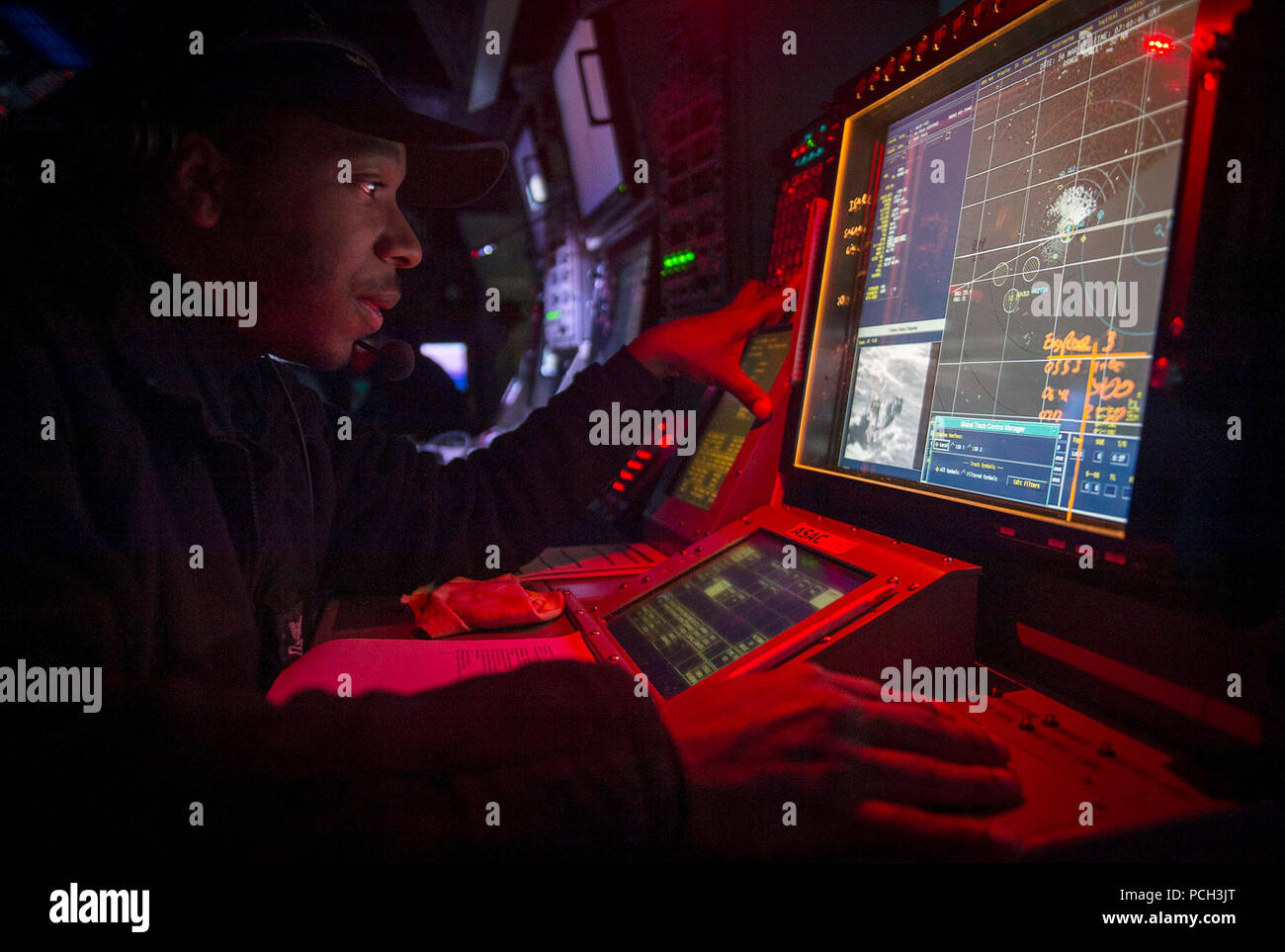 WATERS TO THE WEST OF THE KOREAN PENINSULA (March 10, 2015) Operations Specialist 2nd Class British Fears, assigned to the Arleigh Burke-class guided-missile destroyer USS Michael Murphy (DDG 112), monitors helicopter operations from the combat information center while underway during exercise Foal Eagle 2015. Foal Eagle is a series of annual training events that are defense-oriented and designed to increase readiness and maintain stability on the Korean Peninsula while strengthening the Republic of Korea-U.S. alliance and promoting regional peace and stability of the Indo-Asia-Pacific region. Stock Photo