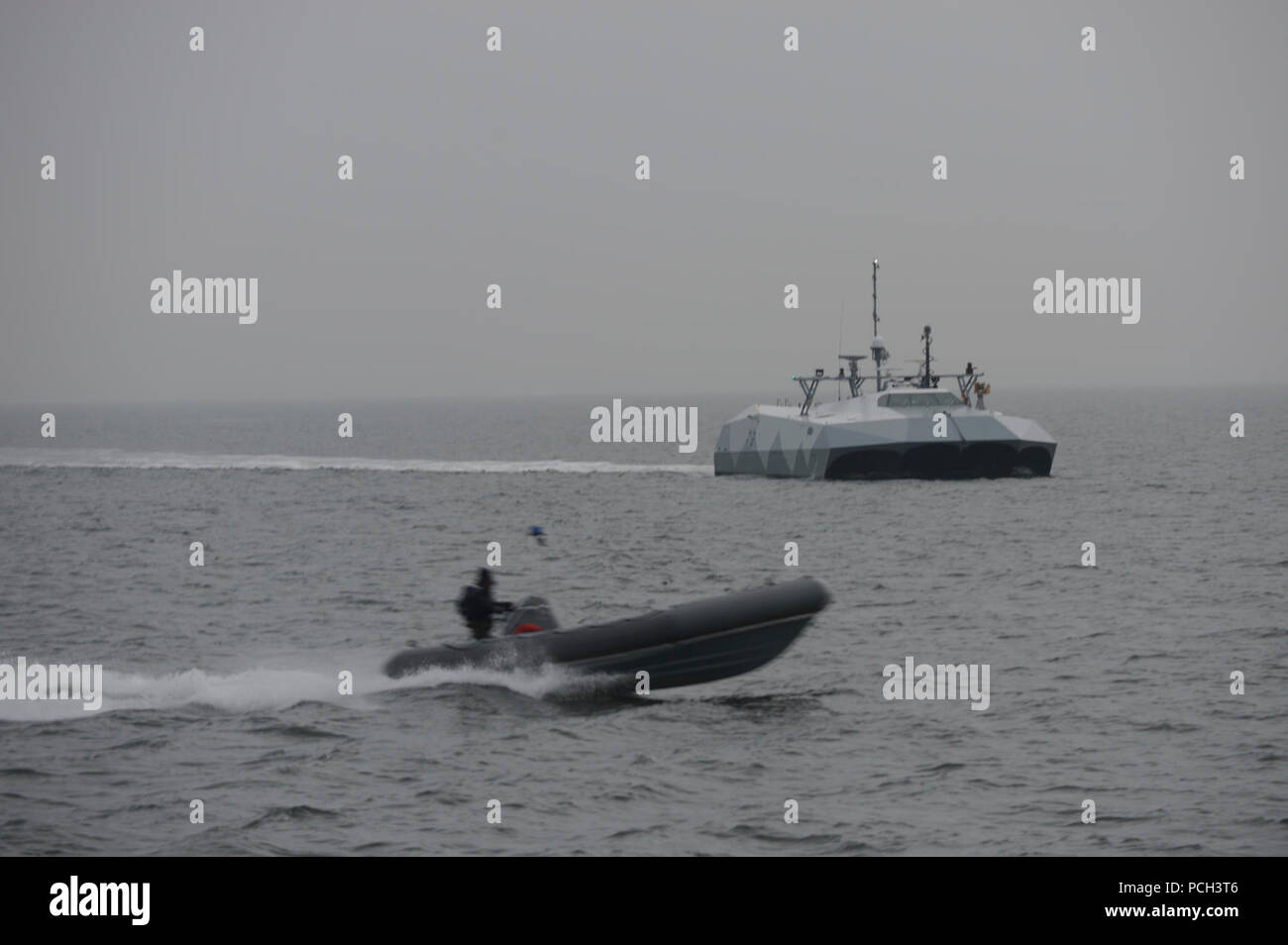 ATLANTIC OCEAN (Jan. 16, 2013) Simulated small boat threats pass by the high-speed experimental boat Stiletto so Sailors assigned to Navy Expeditionary Combat Command (NECC) can observe new technologies in a relevant maritime environment. Stock Photo