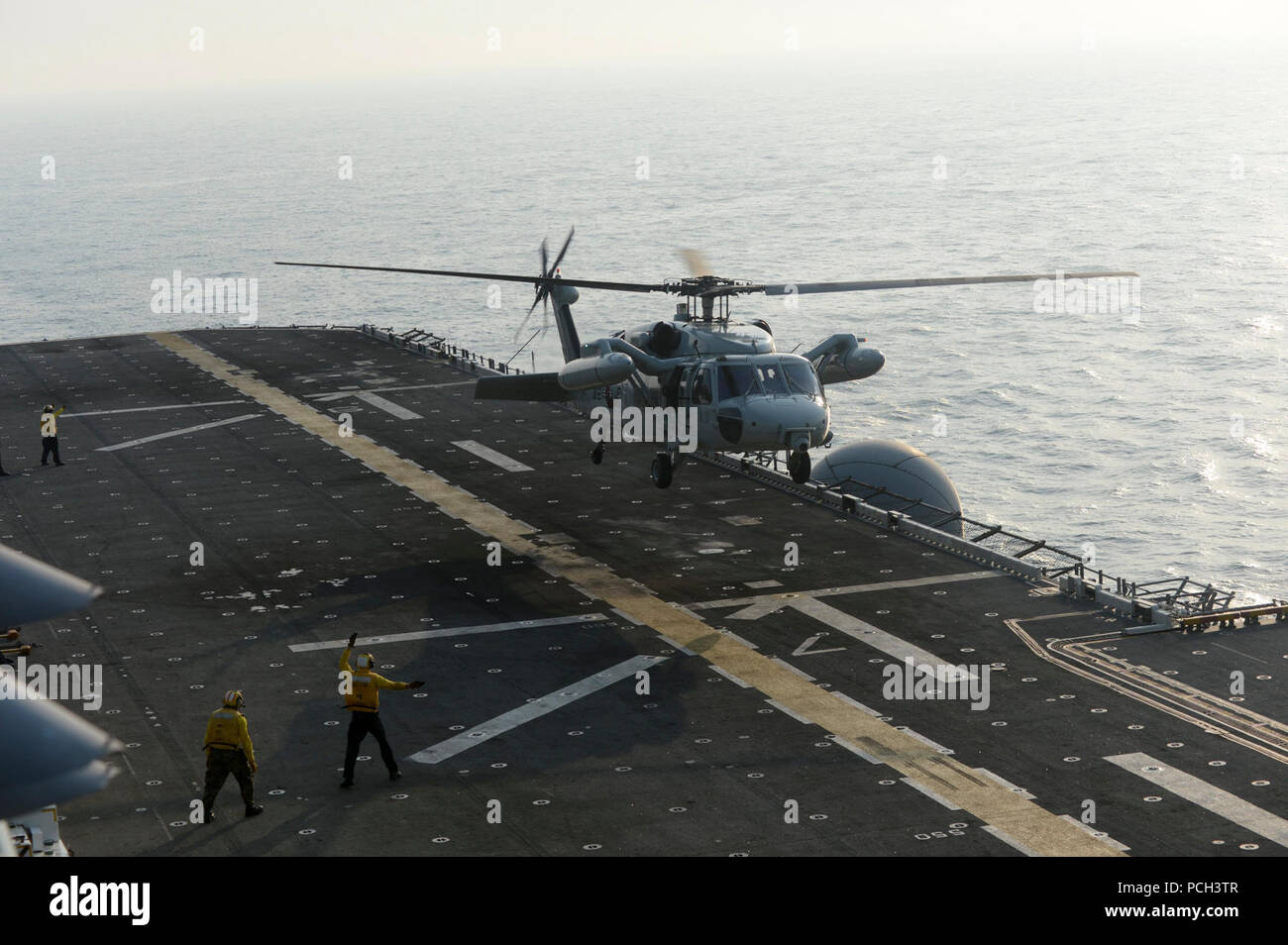 A South Korean navy helicopter lands on the flight deck of the amphibious assault ship USS Bonhomme Richard (LHD 6) in the East China Sea during deck landing qualifications as part of Ssang Yong 14 during Marine Expeditionary Force Exercise (MEFEX) 2014 March 27, 2014. The Bonhomme Richard Amphibious Ready Group participated in MEFEX 2014, a U.S. Marine Corps Forces Pacific-sponsored series of exercises between the U.S. Navy and Marine Corps and South Korean forces. Among the exercises were the Korea Marine Exercise Program, Freedom Banner 14, Ssang Yong 14, Key Resolve 14 and the Combined Mar Stock Photo