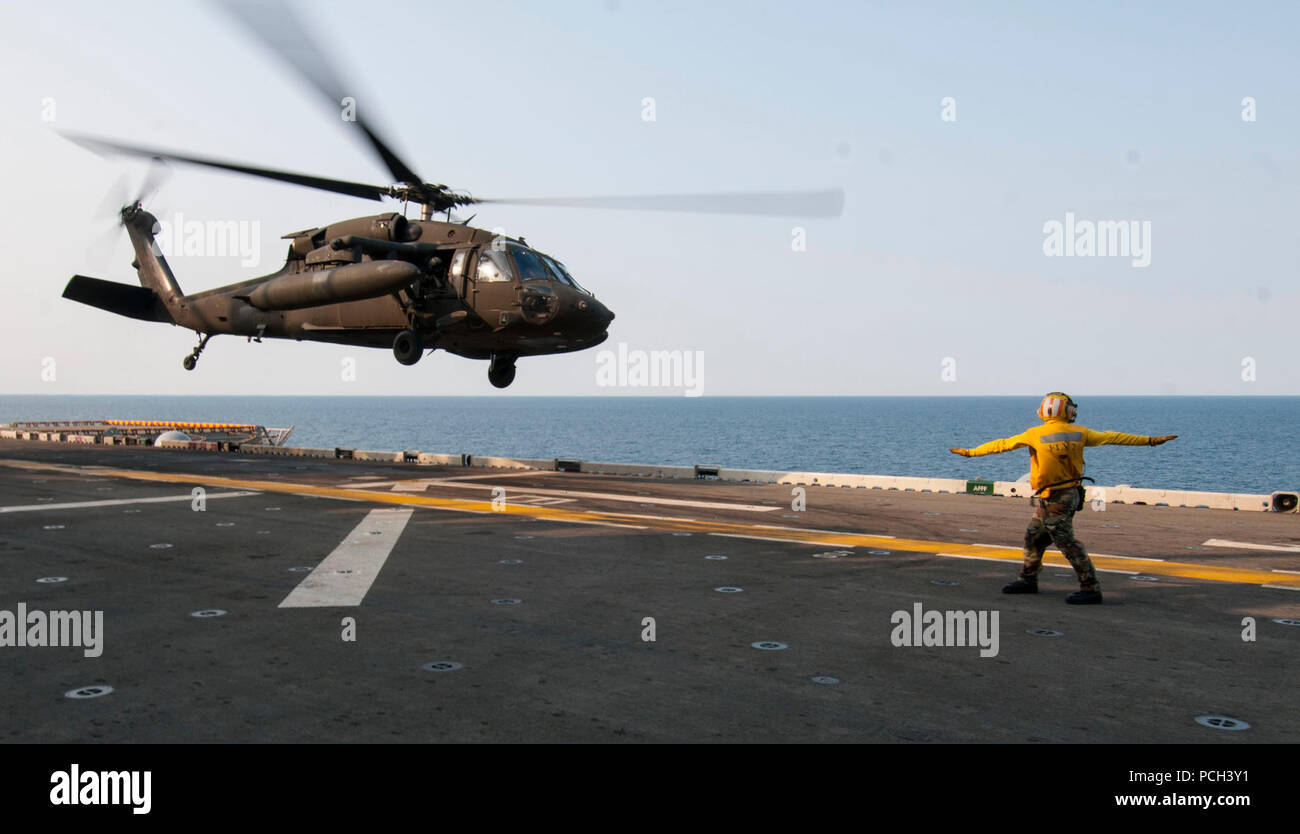 A U.S. Army UH-60L Black Hawk helicopter assigned to the 3rd General Support Aviation Battalion, 2nd Combat Aviation Brigade, 2nd Infantry Division takes off from the amphibious assault ship USS Bonhomme Richard (LHD 6) in the East China Sea April 11, 2014. The Bonhomme Richard was underway in the U.S. 7th Fleet area of responsibility supporting maritime security operations and theater security cooperation efforts. Stock Photo