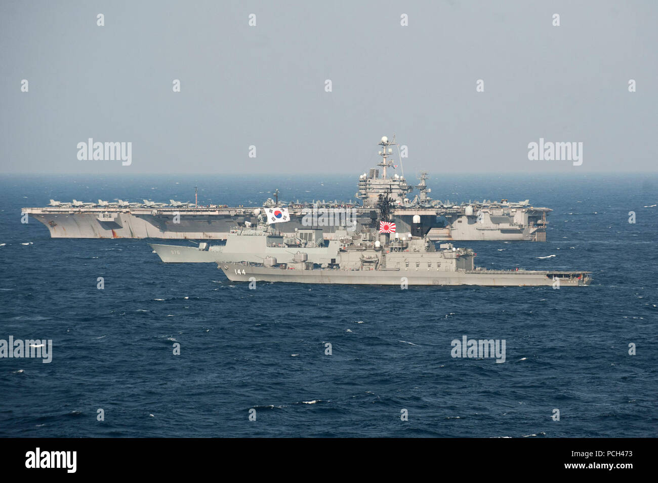 EAST CHINA SEA (June 21, 2012) The Japan Maritime Self Defense Force Shirane-class destroyer JS Kurama (DDH-144), the Republic of Korea navy Chungmugong Yi Sun-sin class destroyer Munmu the Great (DDH-976), and the Nimitz-class Navy aircraft carrier USS George Washington (CVN 73) are in formation during a trilateral exercise. The exercise is designed to improve interoperability and readiness among the three Navies. Stock Photo