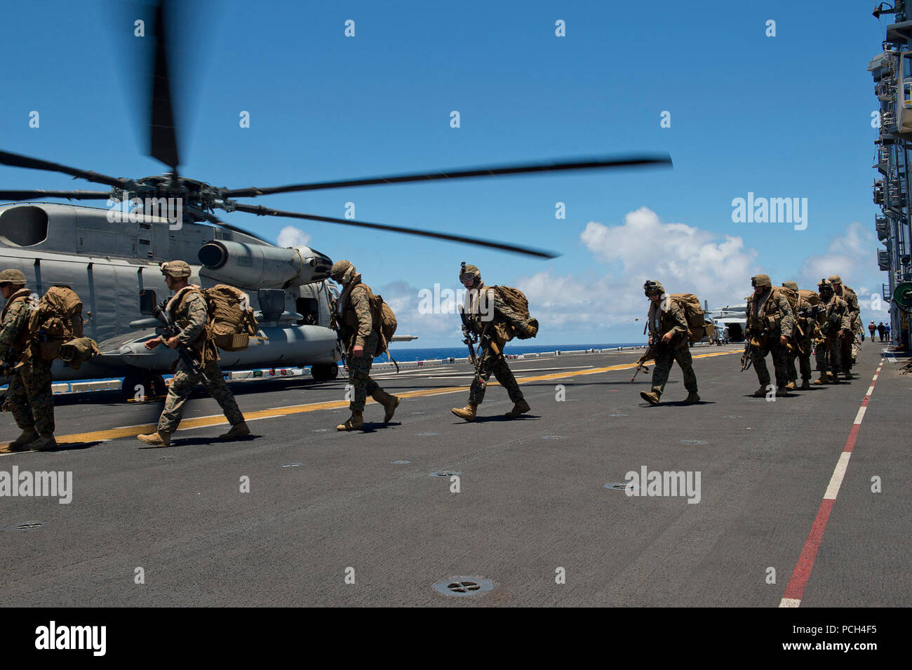 Marines assigned to the 3rd Battalion, 3rd Marine Regiment, board a CH-53E Super Sea Stallion helicopter, assigned to Heavy Marine Helicopter Squadron 463 (HMH-463), on the flight deck of the amphibious assault ship USS Peleliu (LHA 5) during Rim of the Pacific (RIMPAC) Exercise 2014. Twenty-two nations, 49 ships and six submarines, more than 200 aircraft and 25,000 personnel are participating in RIMPAC from June 26 to Aug. 1 in and around the Hawaiian Islands and Southern California. The world's largest international maritime exercise, RIMPAC provides a unique training opportunity that helps Stock Photo