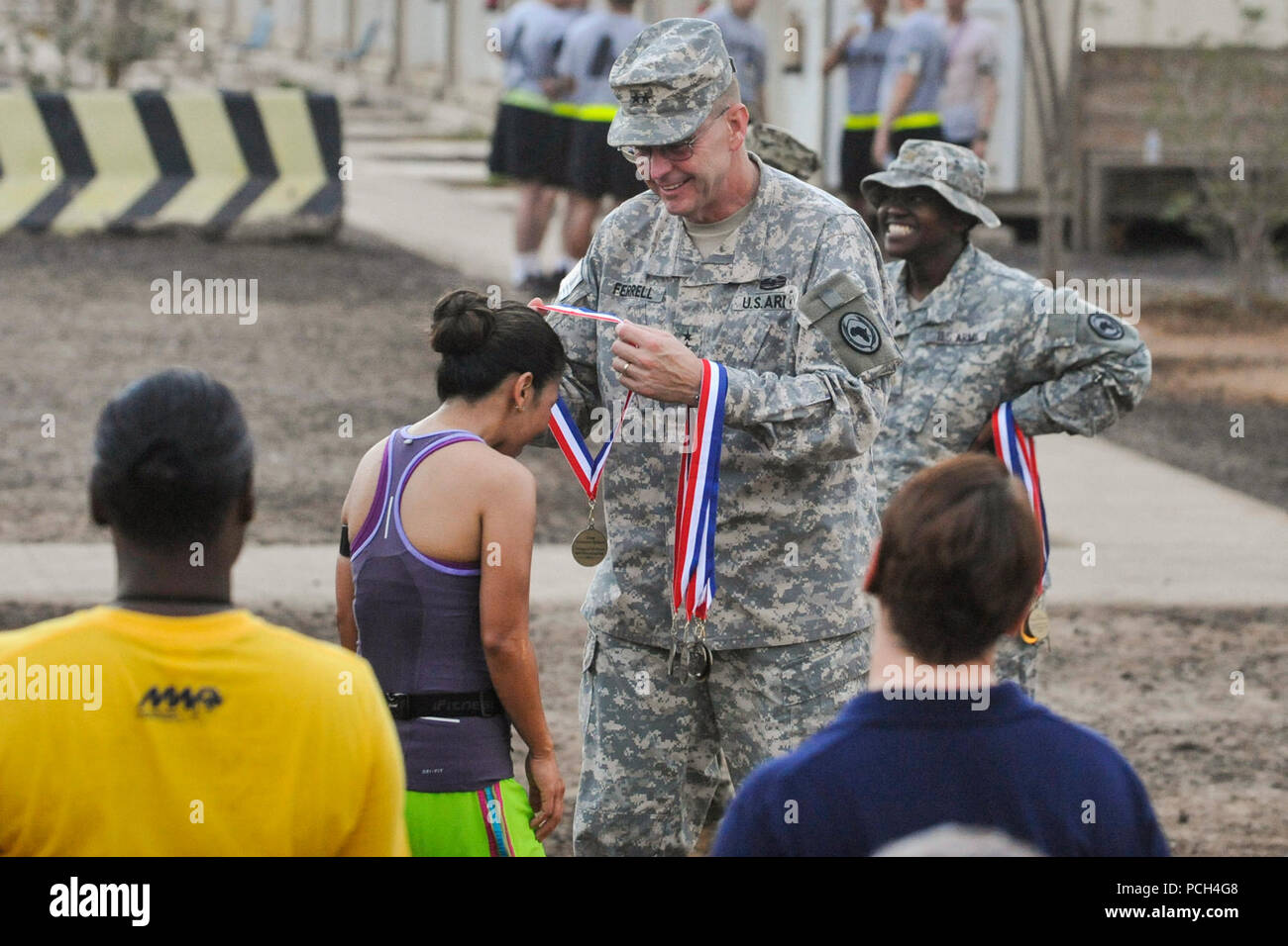 CAMP LEMONNIER, Djibouti (Sept. 21, 2013) Army Maj. Gen. Terry, commander, Combined Joint Task Force - Horn of Africa, presents Air force Maj. Christina Perez with a medal at the finish line of the Air Force Half Marathon and 10K combined races on Camp Lemonnier, held in honor of the Air Force's 66th birthday. Perez finished in second place for the women's category of the half-marathon, with a time of 1:53:21. Stock Photo