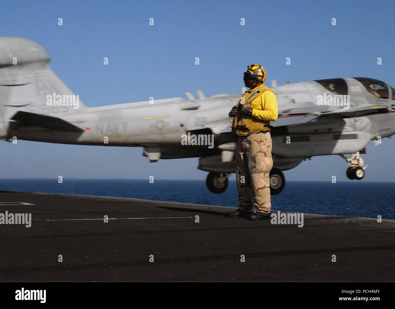 Chief Petty Officer aviation boatswain's mate (handling) Richard McCray stands by as an EA-6B Prowler assigned to the 'Shadowhawks' of Electronic Attack Squadron 141 launches from the aircraft carrier USS Theodore Roosevelt. The Nimitz-Class aircraft carrier and embarked Carrier Air Wing 8 are underway conducting operations in the U.S. 5th Fleet area of responsibility. Stock Photo