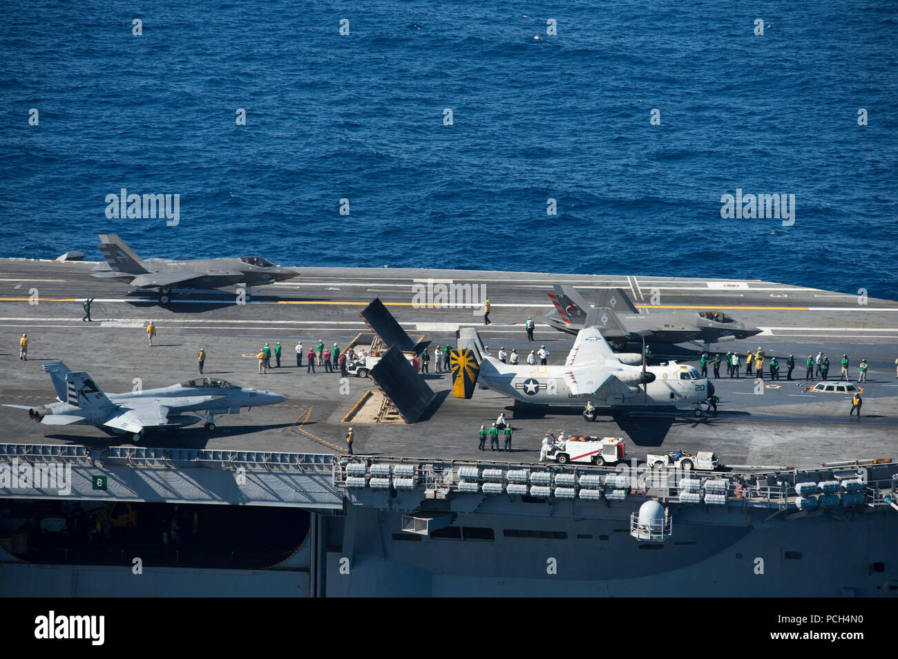 OCEAN (Nov. 4, 2014) Two F-35C Lightning II carrier variant joint strike fighters, an F/A-18 Super Hornet and a C-2A Greyhound conduct flight operations aboard the aircraft carrier USS Nimitz (CVN 68). The F-35 Lightning II Pax River Integrated Test Force from Air Test and Evaluation Squadron (VX) 23 is conducting initial at-sea testing aboard Nimitz. Stock Photo