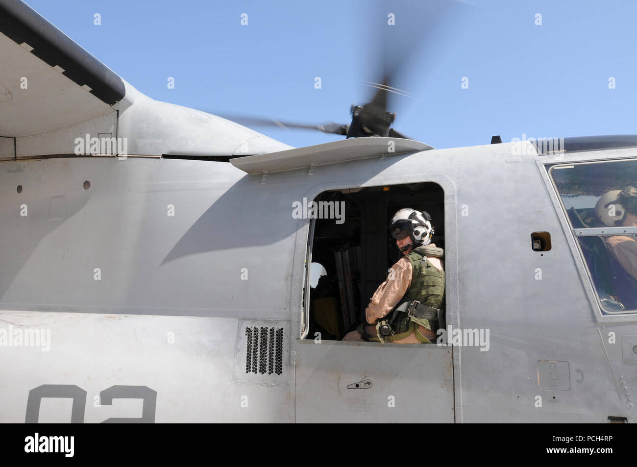 Marine Corps Staff Sgt. Jenna Kumdh, from Marine Medium Tiltrotor Squadron 162, looks out the window of an MV-22 Osprey, watching for other aircraft on the flight line at U.S. Naval Station Guantanamo Bay, Jan. 24. The aircraft, scheduled to fly to the USS Bataan with supplies for Haiti, is here in support of Operation Unified Response. Stock Photo