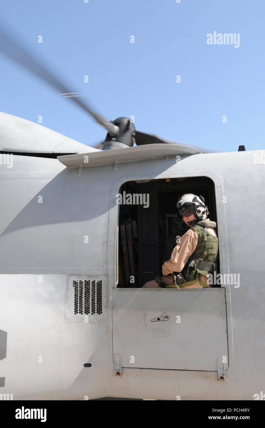 Marine Corps Staff Sgt. Jenna Kumdh, from Marine Medium Tiltrotor Squadron 162, looks out the window of an MV-22 Osprey, watching for other aircraft on the flight line at U.S. Naval Station Guantanamo Bay, Jan 24. The aircraft, scheduled to fly to the USS Bataan with supplies for Haiti, is here in support of Operation Unified Response. Stock Photo