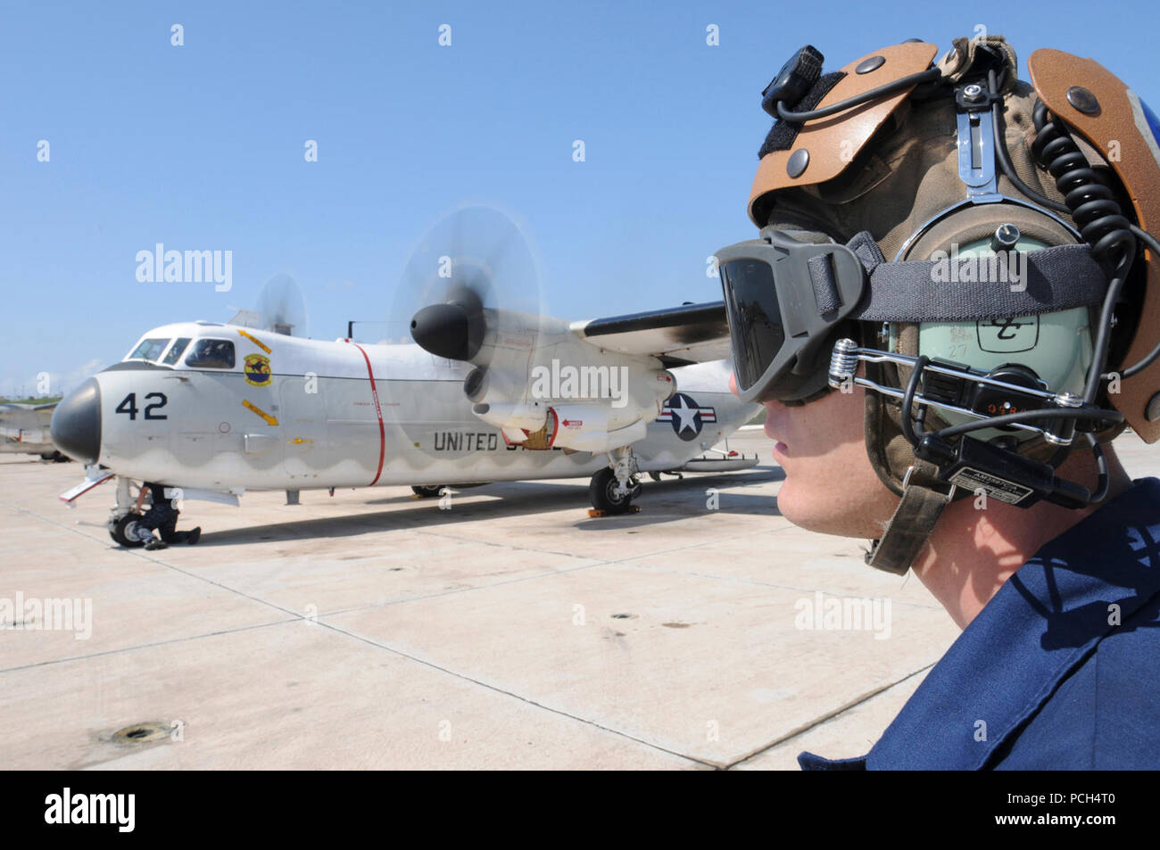 Navy Airman Michael Megyesi, an aviation electronic technician, conducts preflight communications check while a C-2 Greyhound aircraft prepares for departure from U.S. Naval Station Guantanamo Bay, Jan. 24. The aircraft is flying humanitarian assistance to Haiti in support of Operation Unified Response. Stock Photo