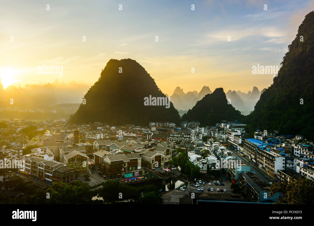 Sunrise in Yangshuo China over the karst rocks and the city Stock Photo