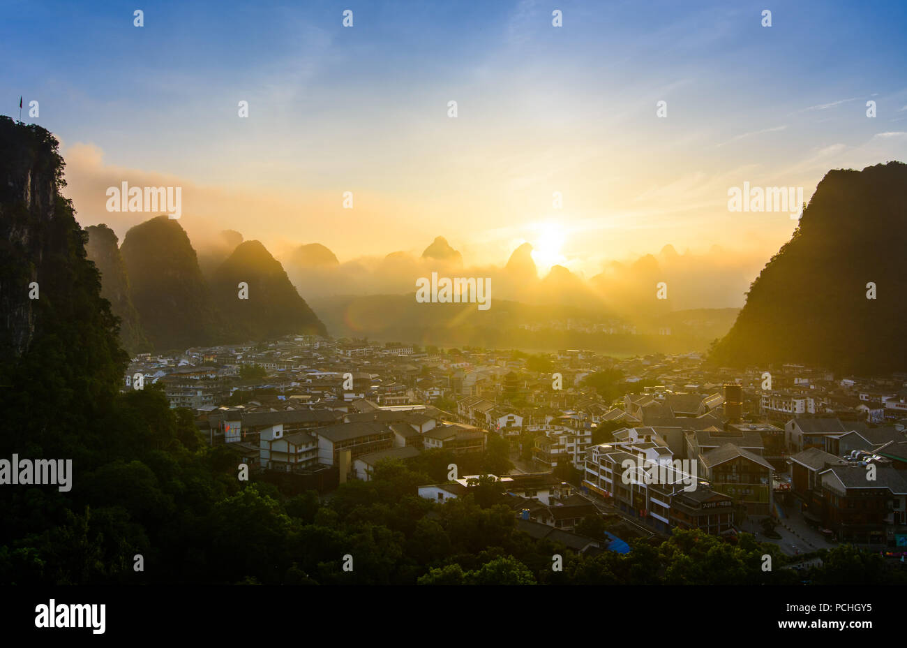Sunrise in Yangshuo China over the karst rocks and the city Stock Photo