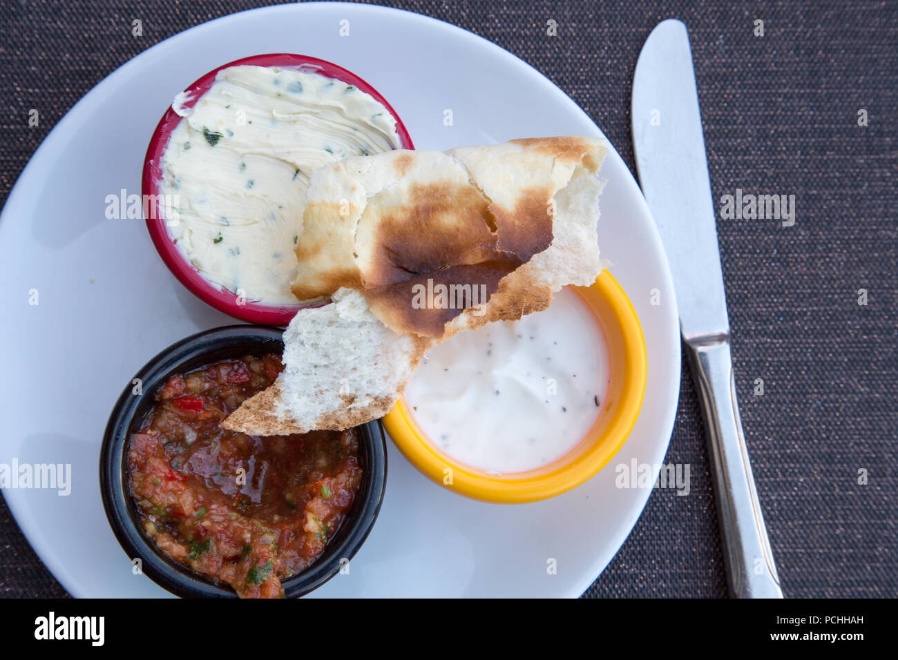 A selection of dips including Garlic butter, Minted yogurt and Tomato and chili salsa with a