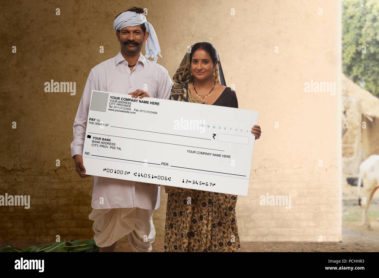 Rural couple holding bank cheque Stock Photo - Alamy