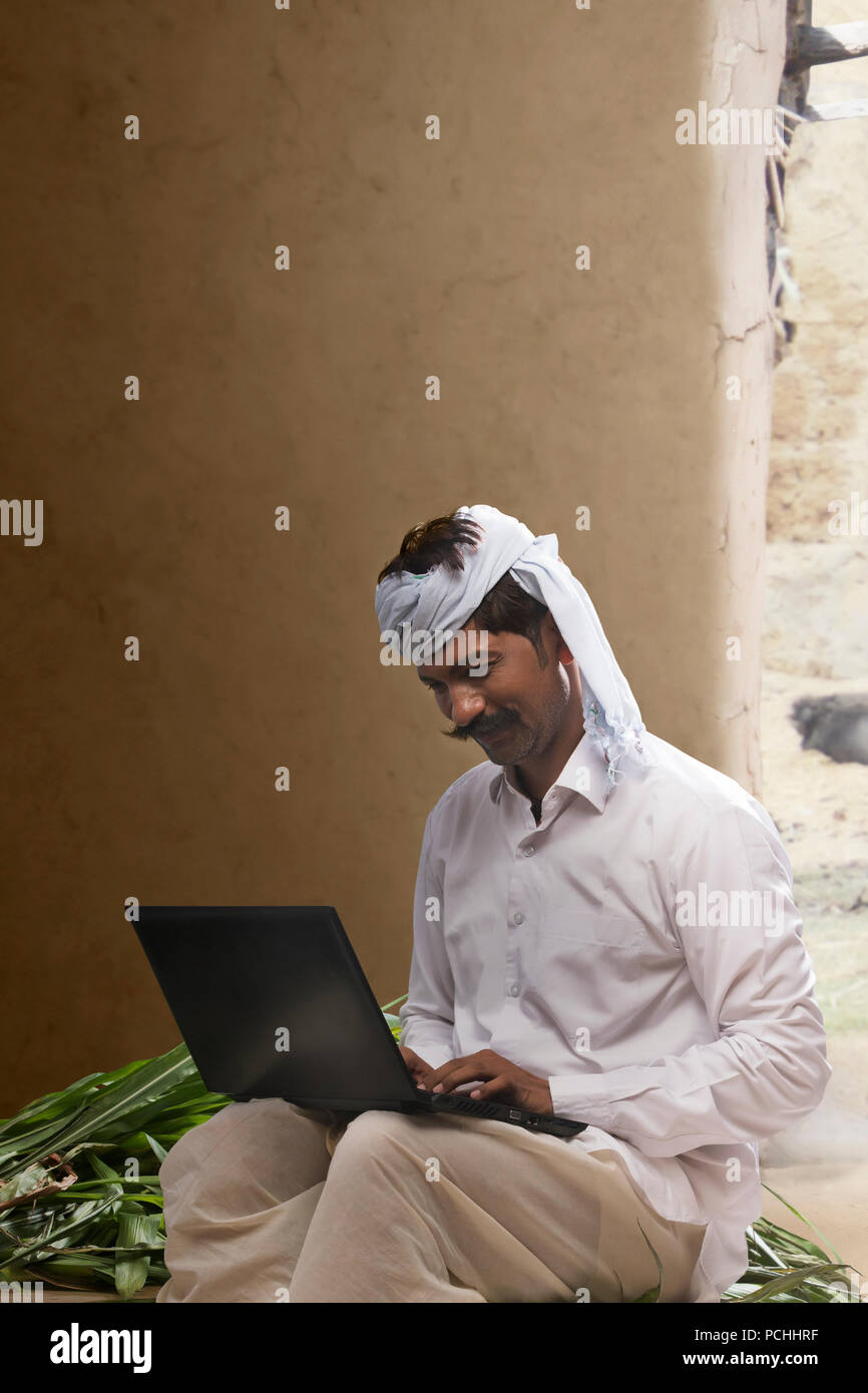 Indian farmer using laptop Stock Photo