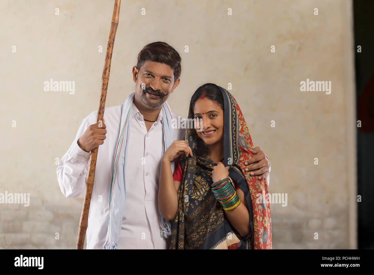 Portrait of rural couple holding stick Stock Photo - Alamy