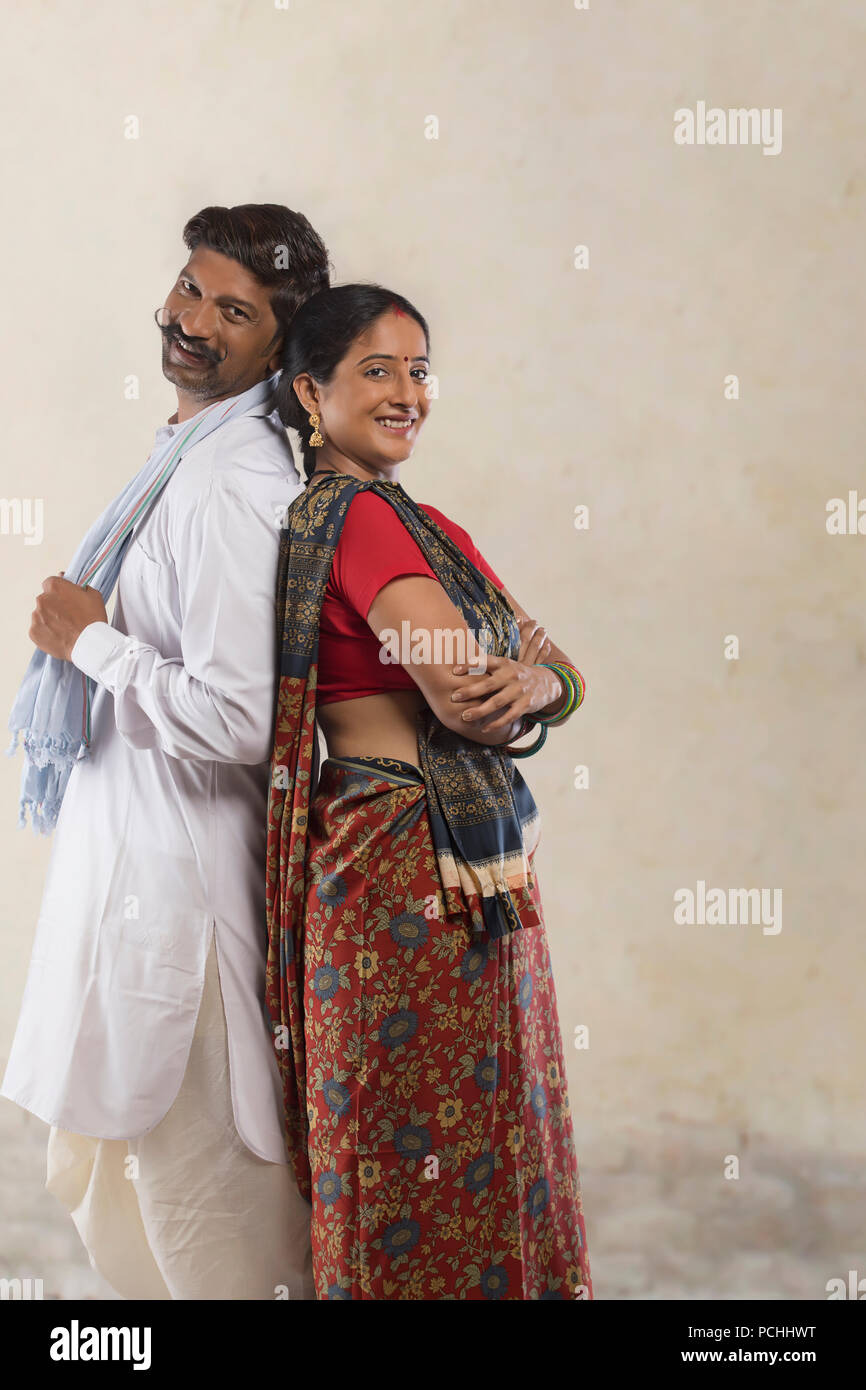 Portrait of rural couple standing back to back Stock Photo - Alamy