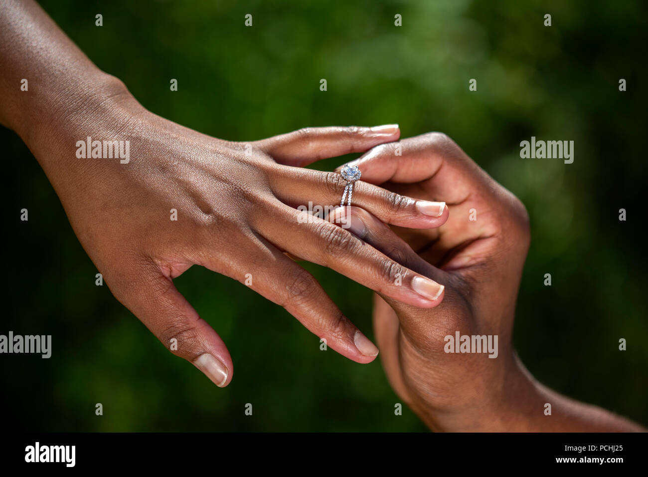 Engagement ring being put on African woman's finger Stock Photo