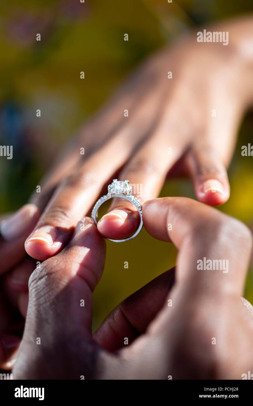 Engagement ring being put on African woman's finger Stock Photo