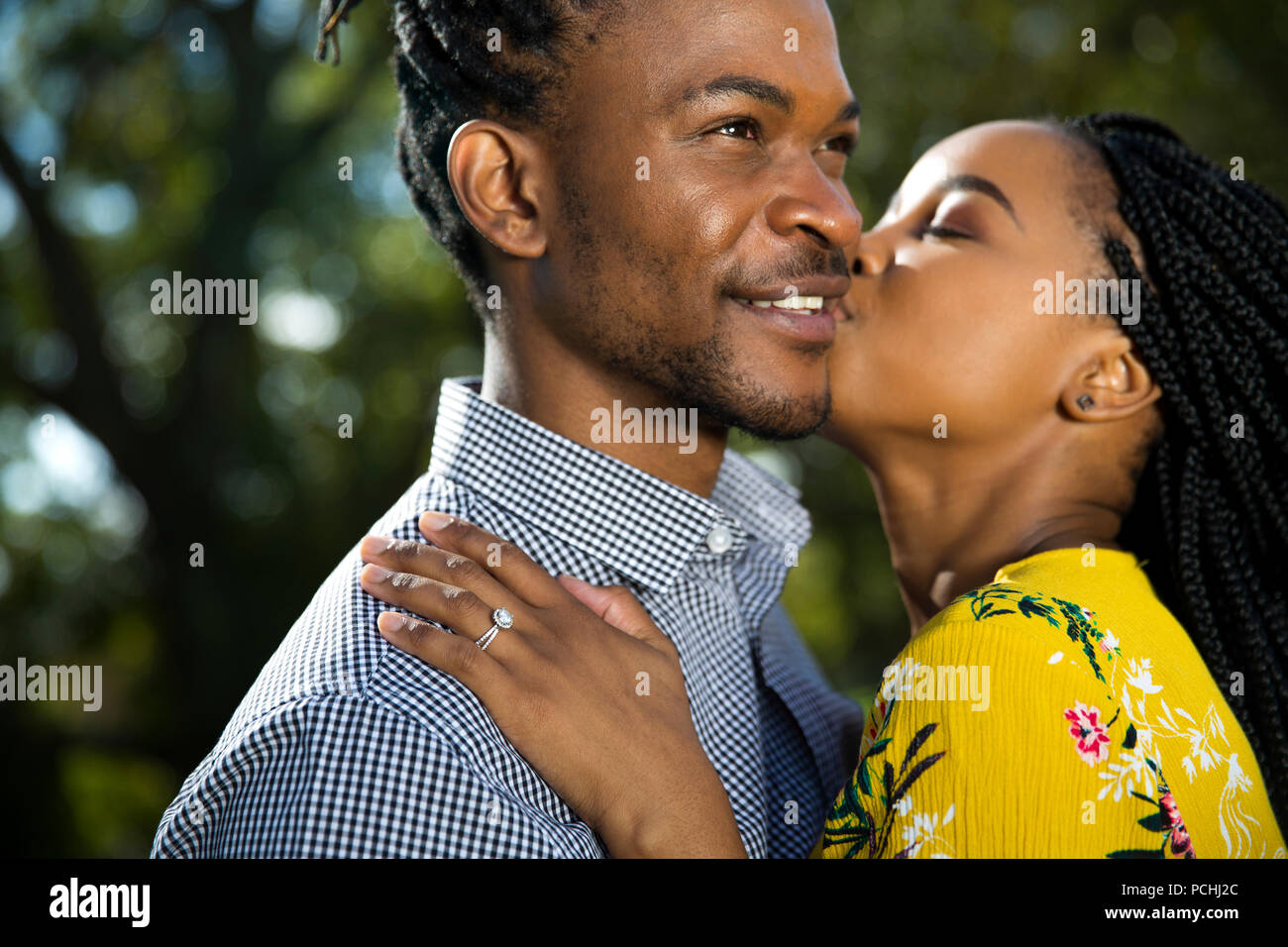 African woman kissing African man on cheek Stock Photo