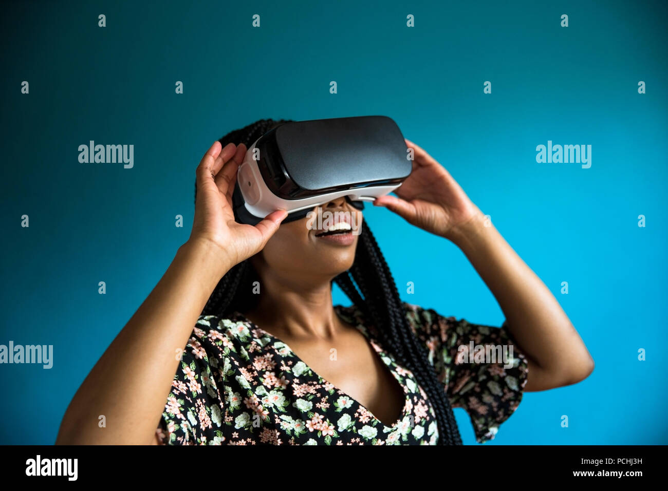 African woman looking through VR headset Stock Photo