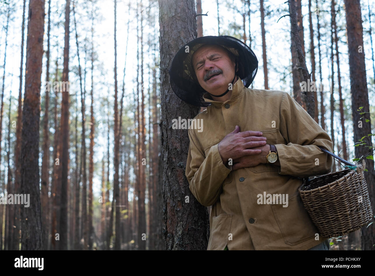 Senior caucasian man having heart attack in park while walking alone. Stock Photo