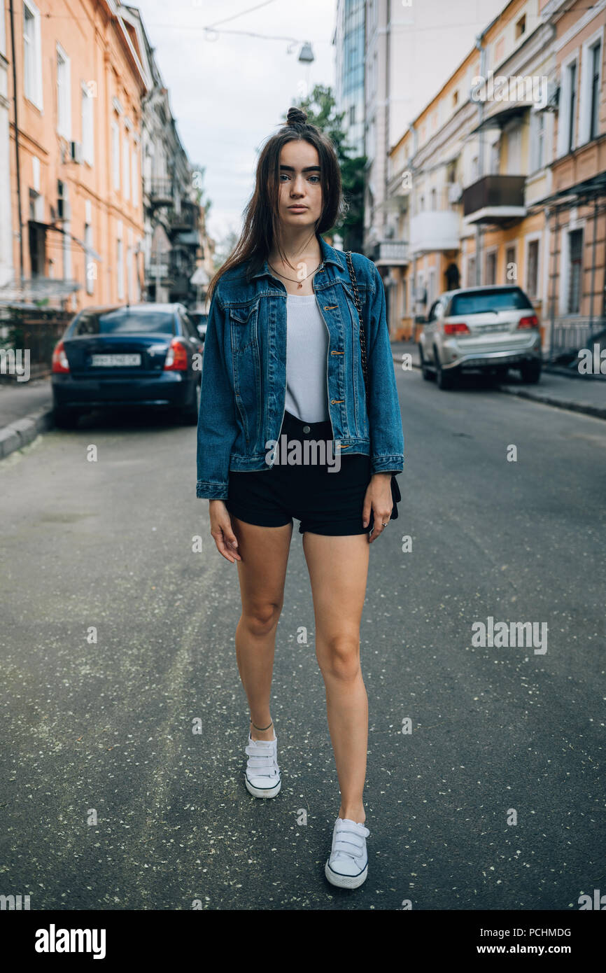 Full body portrait of beautiful fashionable young woman wearing blue denim  jacket and black shorts posing on city street. Cute girl with trendy hairst  Stock Photo - Alamy