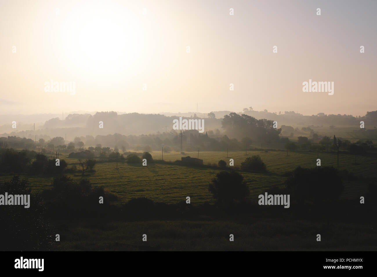 View over the countryside in Mallorca, Spain with morning fog everywhere over the hills and the trees Stock Photo