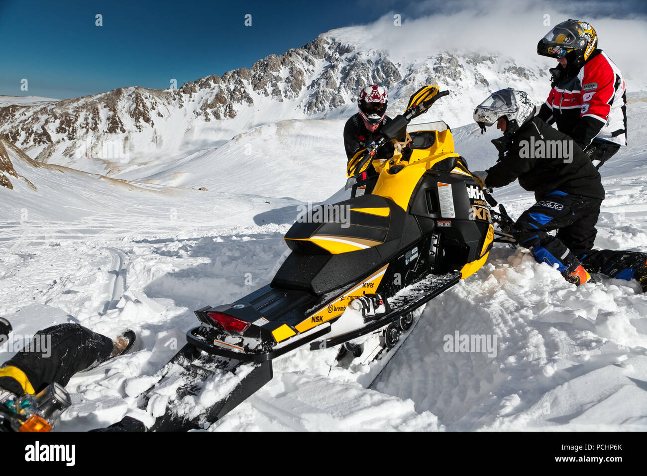 Men dig snowmobile BRP mxz. Russia, Adygea, Lago-Naki plateau, February 3, 2012. Stock Photo