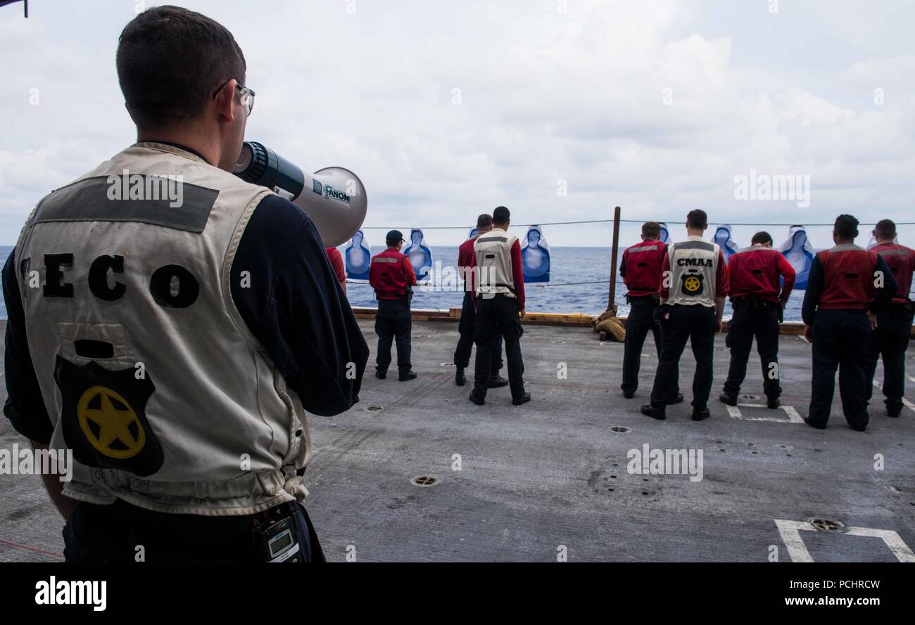 180729-N-OY799-0020 WATERS SOUTH OF JAPAN (July 29, 2018) Master-at-Arms 1st Class Ethan Acosta, from Castroville, Texas, instructs Sailors on the next course of fire during a small arms qualification aboard the Navy’s forward-deployed aircraft carrier, USS Ronald Reagan (CVN 76). Ronald Reagan, the flagship of Carrier Strike Group 5, provides a combat-ready force that protects and defends the collective maritime interests of its allies and partners in the Indo-Pacific region. (U.S. Navy photo by Mass Communication Specialist 2nd Class Kenneth Abbate) Stock Photo