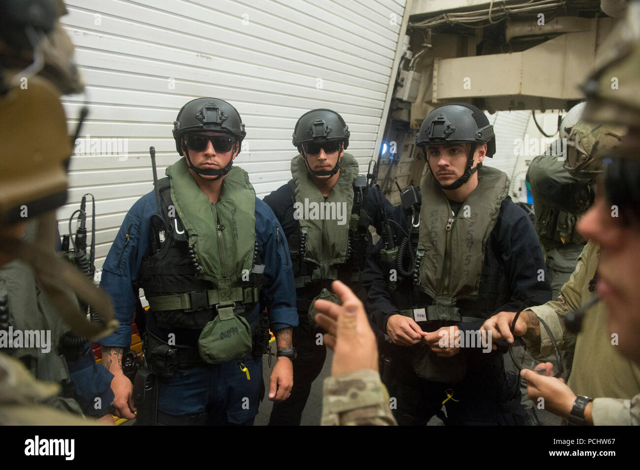 180729-G-ZV557-1250 PACIFIC OCEAN (July 29, 2018) Service members aboard the U.S. Coast Guard Cutter Bertholf (WMSL 750) prepare for a mock boarding operation July 29, 2018, during the Rim of the Pacific (RIMPAC) exercise.  Twenty-five nations, 46 ships and five submarines, and about 200 aircraft and 25,000 personnel are participating in RIMPAC from June 27 to Aug. 2 in and around the Hawaiian Island and Southern California.  The world’s largest international maritime exercise, RIMPAC provides a unique training opportunity while fostering and sustaining cooperative relationships among the part Stock Photo