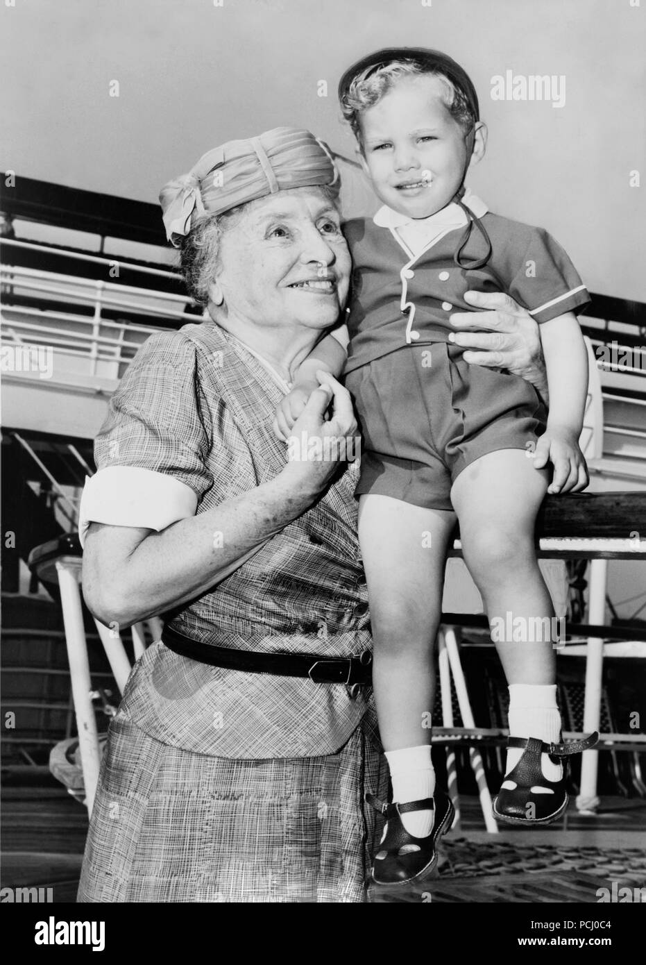 Helen Keller, left, with two-year-old Donald Hart on board the ocean liner Independence after the ship docked in 1956 at New York City, New York. Helen Keller (June 27, 1880 – June 1, 1968) was an American author, political activist, and lecturer. She was the first deaf-blind person to earn a bachelor of arts degree. Stock Photo