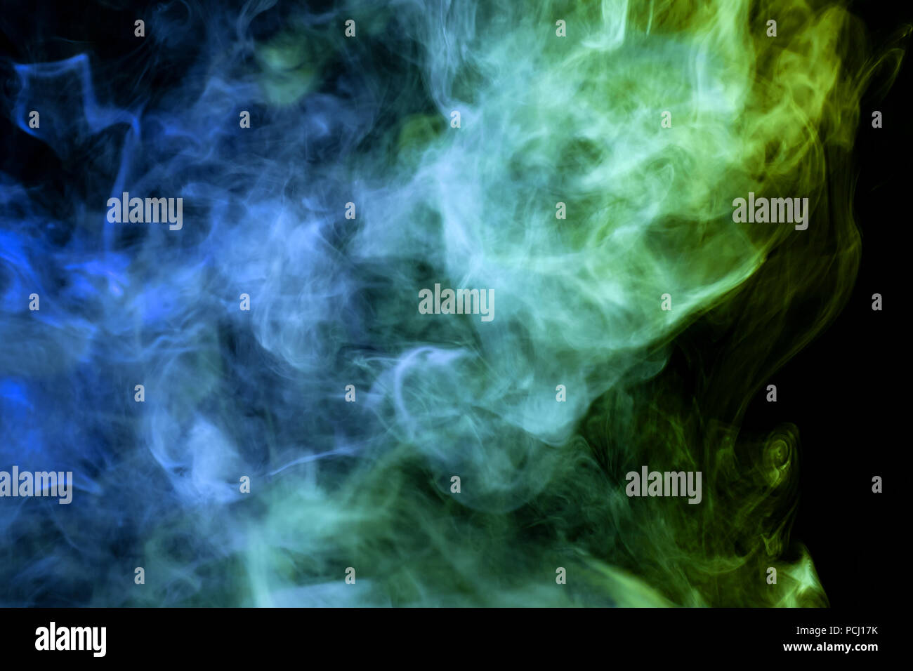 Colorful green and blue smoke on a black isolated background ...