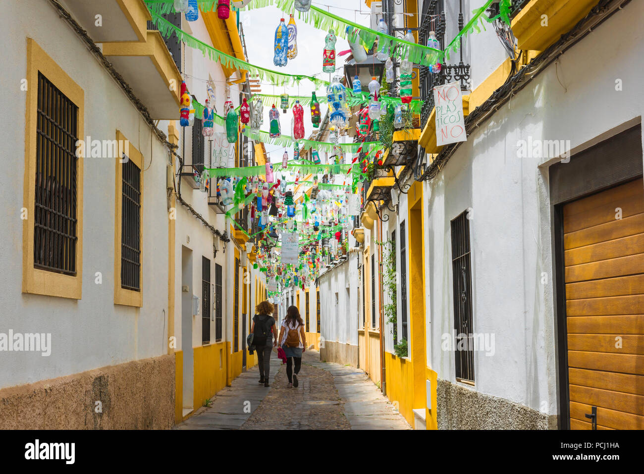 Plastic pollution, waste plastic bottles hanging above a street serve as a protest and warning against global pollution from plastics, Cordoba, Spain Stock Photo