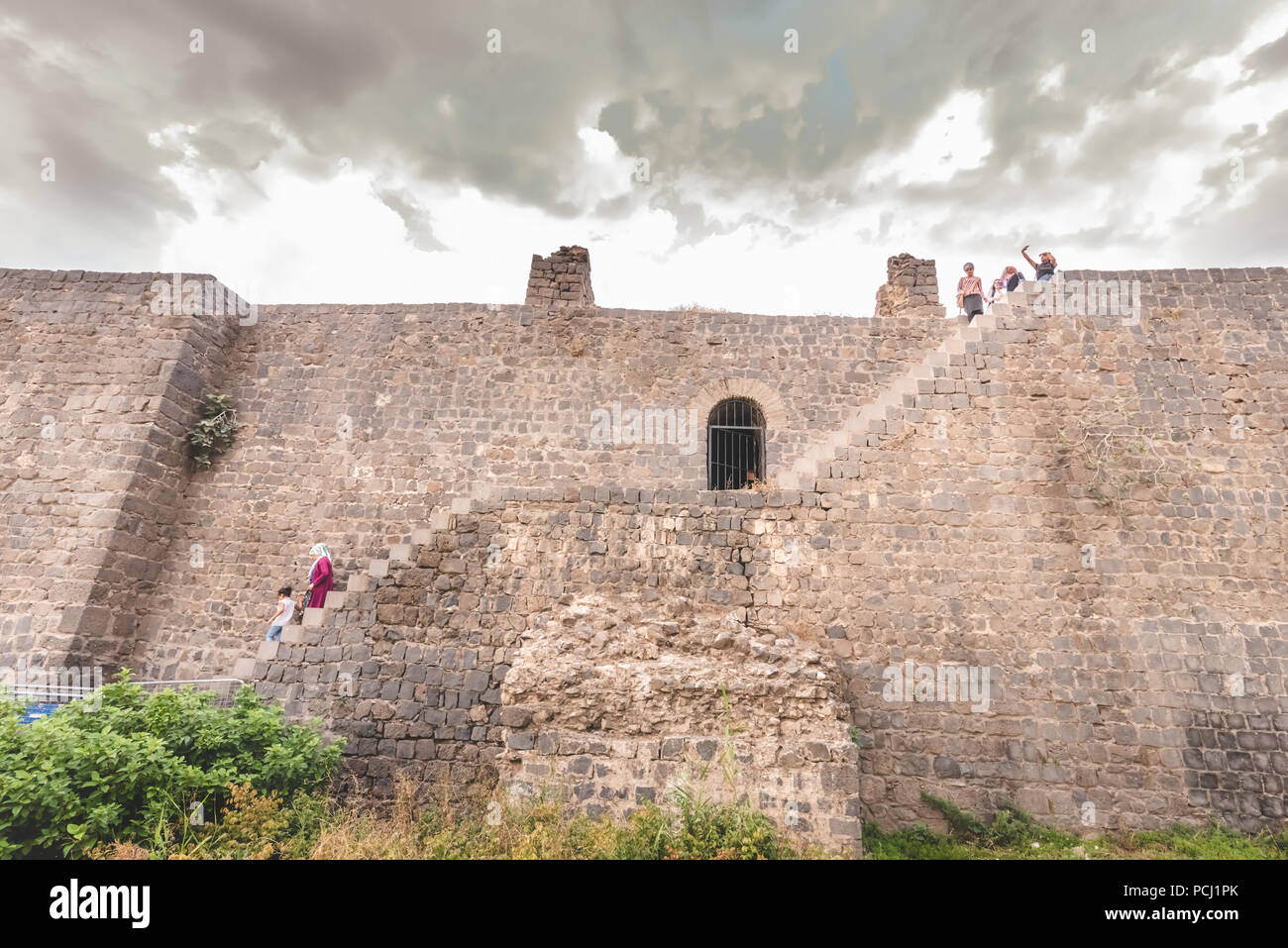 Unidentified people climb up  historical walls in sur region,Diyarbakir,Turkey.15 July 2018 Stock Photo