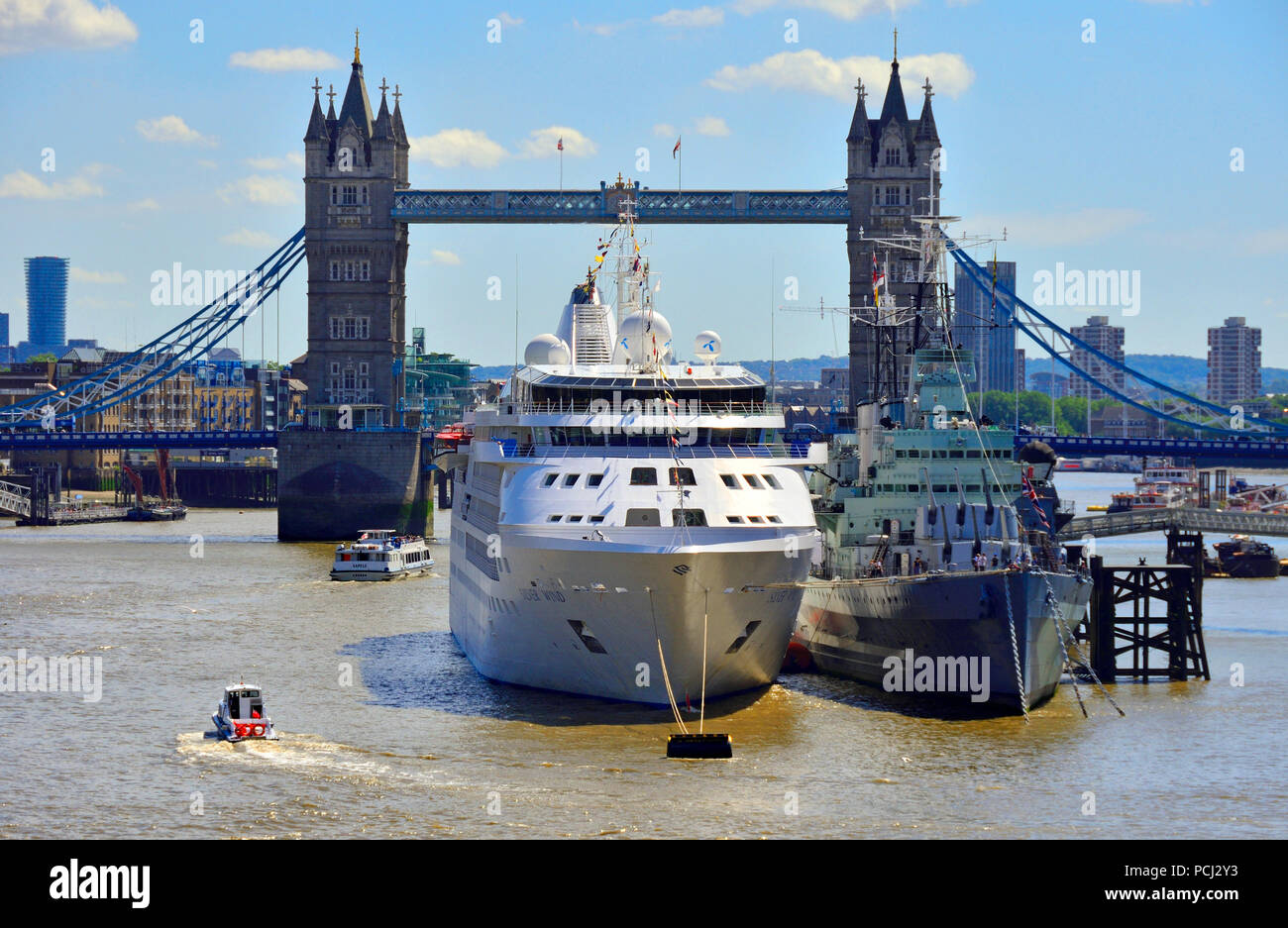 Silver Wind cruise ship moored next to HMS Belfast on the River Thames, London, England, UK. August 2018 Tower Bridge behind Stock Photo