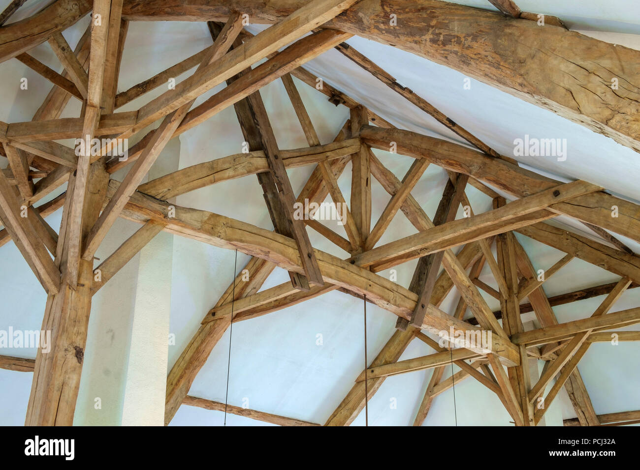 Looking up at the massive restored interior timber roof construction in a large  old French farmhouse Stock Photo