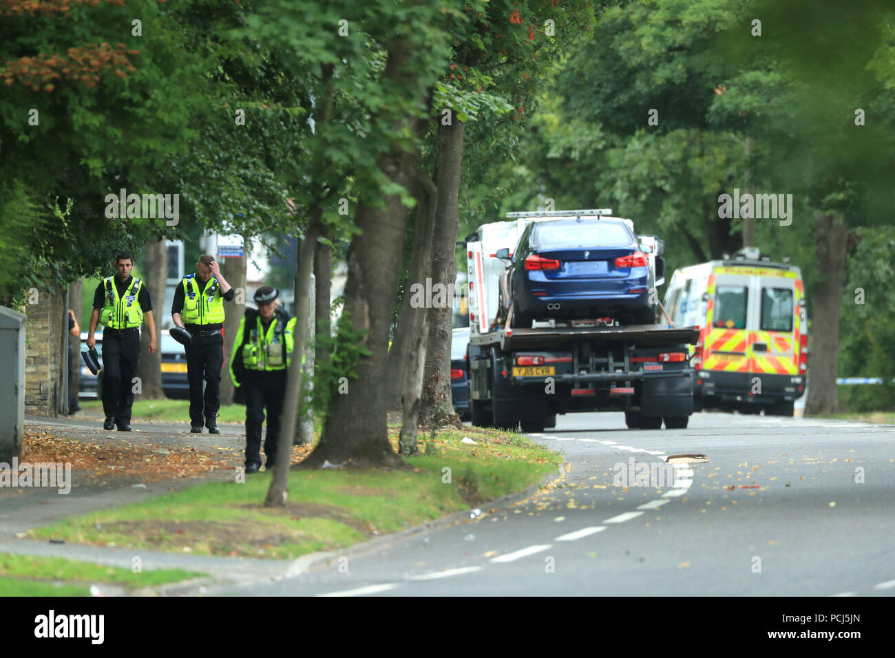 Police officers near the scene on Bingley Road at the junction with Toller Lane in Bradford following a road traffic collision where four males died in a car which was being followed by an unmarked police vehicle when it crashed. Stock Photo