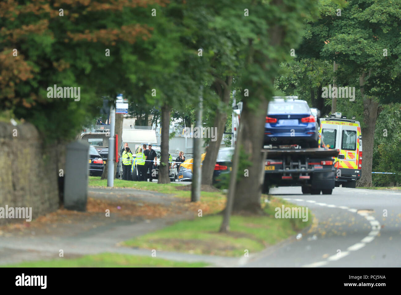 Police officers at the scene on Bingley Road at the junction with Toller Lane in Bradford following a road traffic collision where four males died in a car which was being followed by an unmarked police vehicle when it crashed. Stock Photo