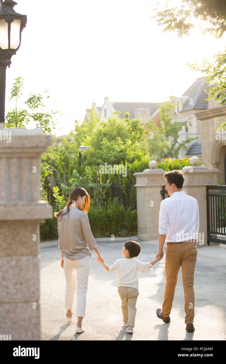 Happy young Chinese family holding hands walking Stock Photo - Alamy