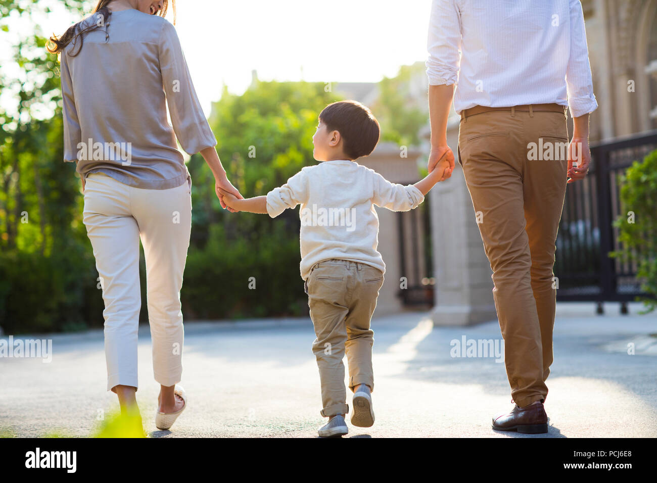 Happy young Chinese family holding hands walking Stock Photo