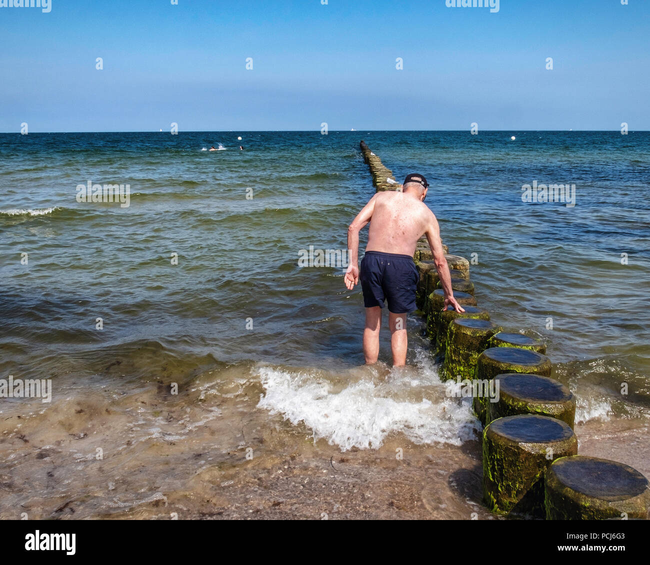 Germany Loddin,Stubbenfelde Beach. Coastal bathing resort on the island of Usedom on the Baltic Sea. Senior elderly man cools off in sea Stock Photo