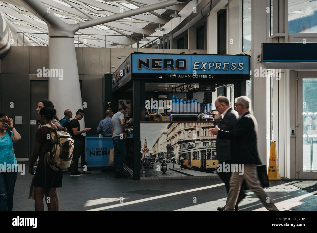 People walking in front of Cafe Nero stall inside King's Cross station