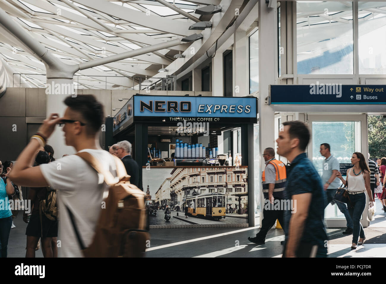 People walking in front of Cafe Nero stall inside King's Cross station