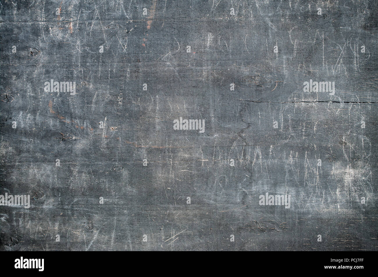 old grey wooden board with unreadable white letters and words on it Stock Photo
