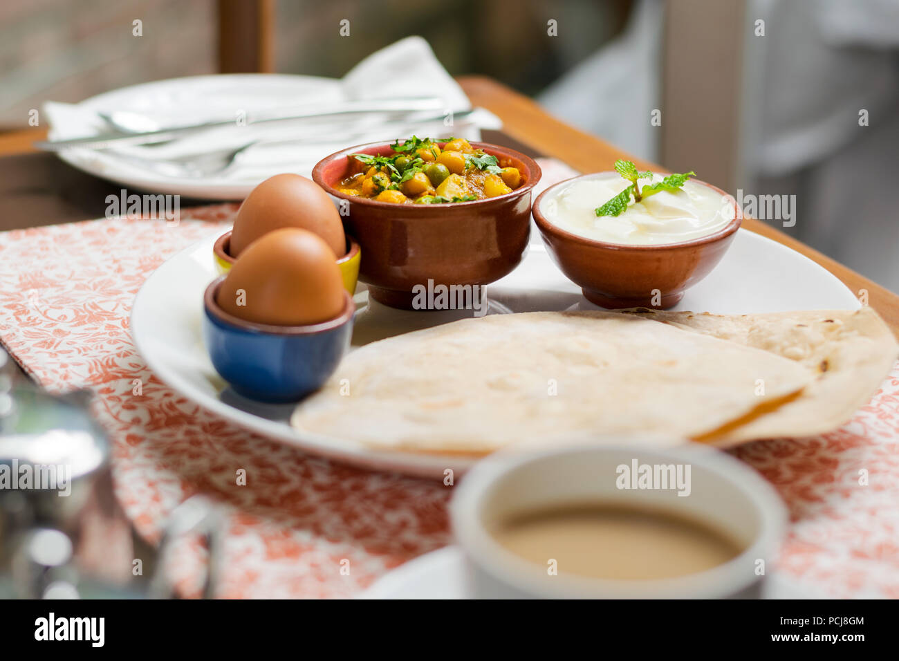 Traditional Indian-Nepali breakfast plate with parata flat bread, eggs