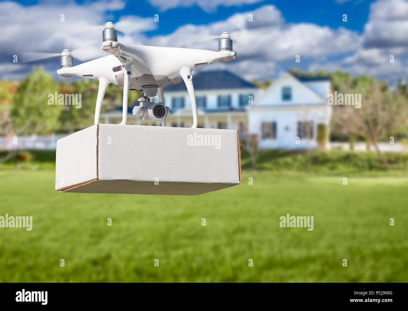 Unmanned Aircraft System (UAV) Quadcopter Drone Delivering Package At House. Stock Photo