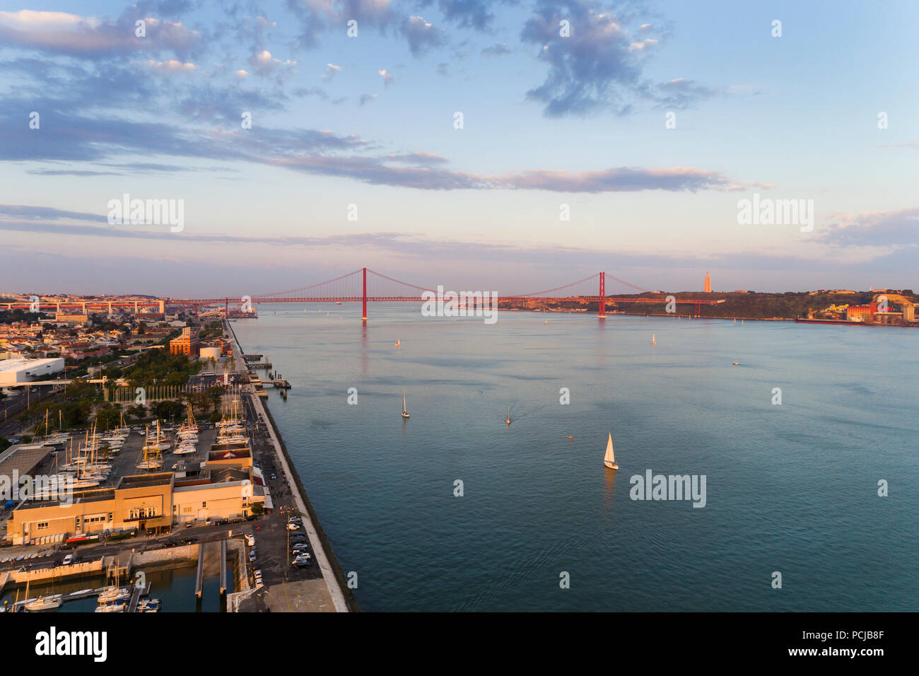 Aerial view of the Tagus River (RIo Tejo) in the city of Lisbon with sail boats and the 25 of April Bridge on the background; Concept for travel in Po Stock Photo