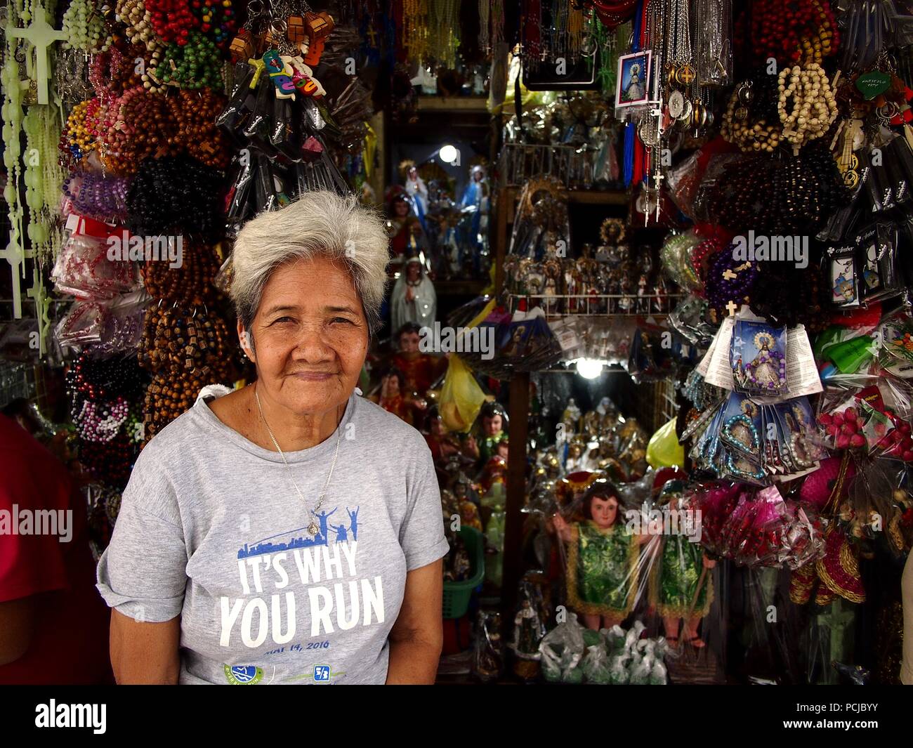 ANTIPOLO CITY, PHILIPPINES JULY 30, 2018 An elderly Asian woman sells religious items in her
