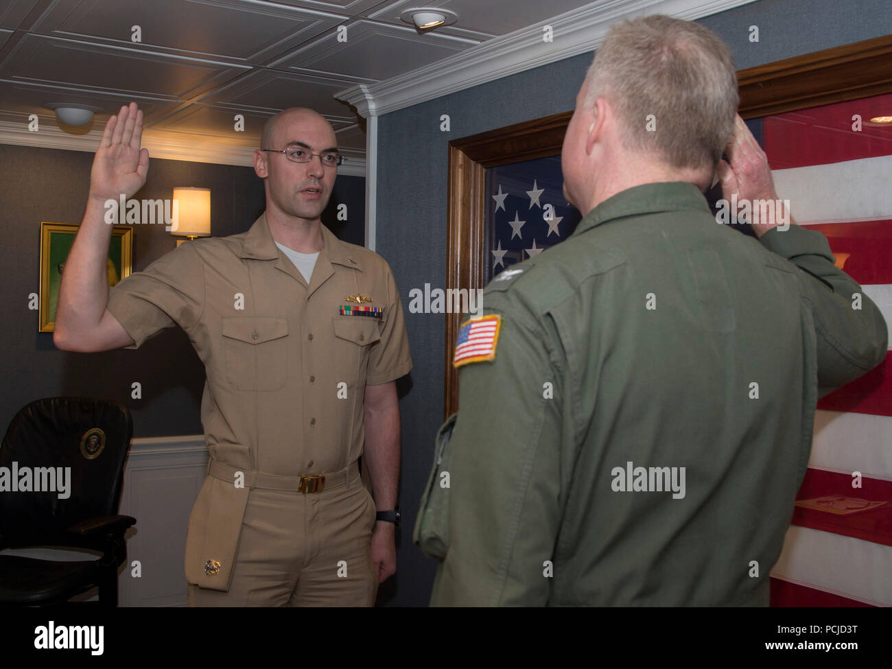 NEWPORT NEWS, Va. (Aug. 1, 2018) Lt. j.g. Zachary Klassen, from Phoenix, assigned to USS Gerald R. Ford’s (CVN 78) weapons department, recites the oath of office from Capt. Richard McCormack, Ford's commanding officer, during a promotion ceremony aboard Ford. (U.S. Navy photo by Mass Communication Specialist 2nd Class Cat Campbell) Stock Photo