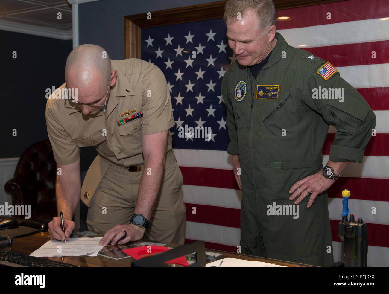 NEWPORT NEWS, Va. (Aug. 1, 2018) Lt. j.g. Zachary Klassen, from Phoenix, assigned to USS Gerald R. Ford’s (CVN 78) weapons department, signs his delivery of permanent appointment paperwork during a promotion ceremony aboard Ford. (U.S. Navy photo by Mass Communication Specialist 2nd Class Cat Campbell) Stock Photo
