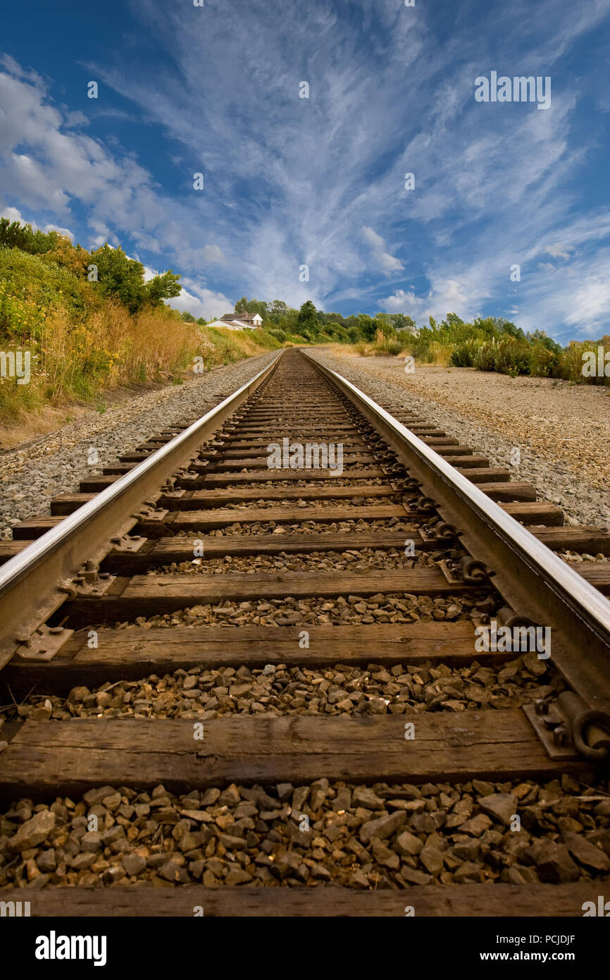 Railroad tracks disappearing into a point in the distance Stock Photo